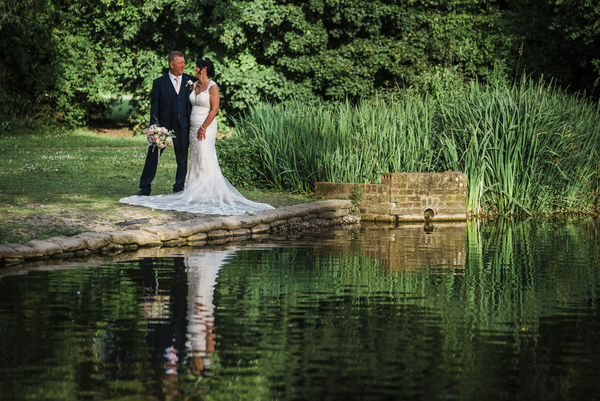 Bride and Groom reflected in lake 